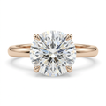 Round clear-stone solitaire ring with slender polished band on white