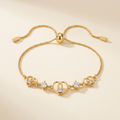 Gold-tone triple heart slider bracelet on a neutral ivory background