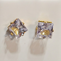 Close-up of square clear-stone stud earrings with gold-tone bar prongs