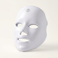 Glossy white contoured beauty face mask with eye, nose and mouth openings on a white background