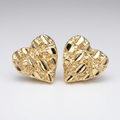 Close-up of gold-tone textured heart earrings