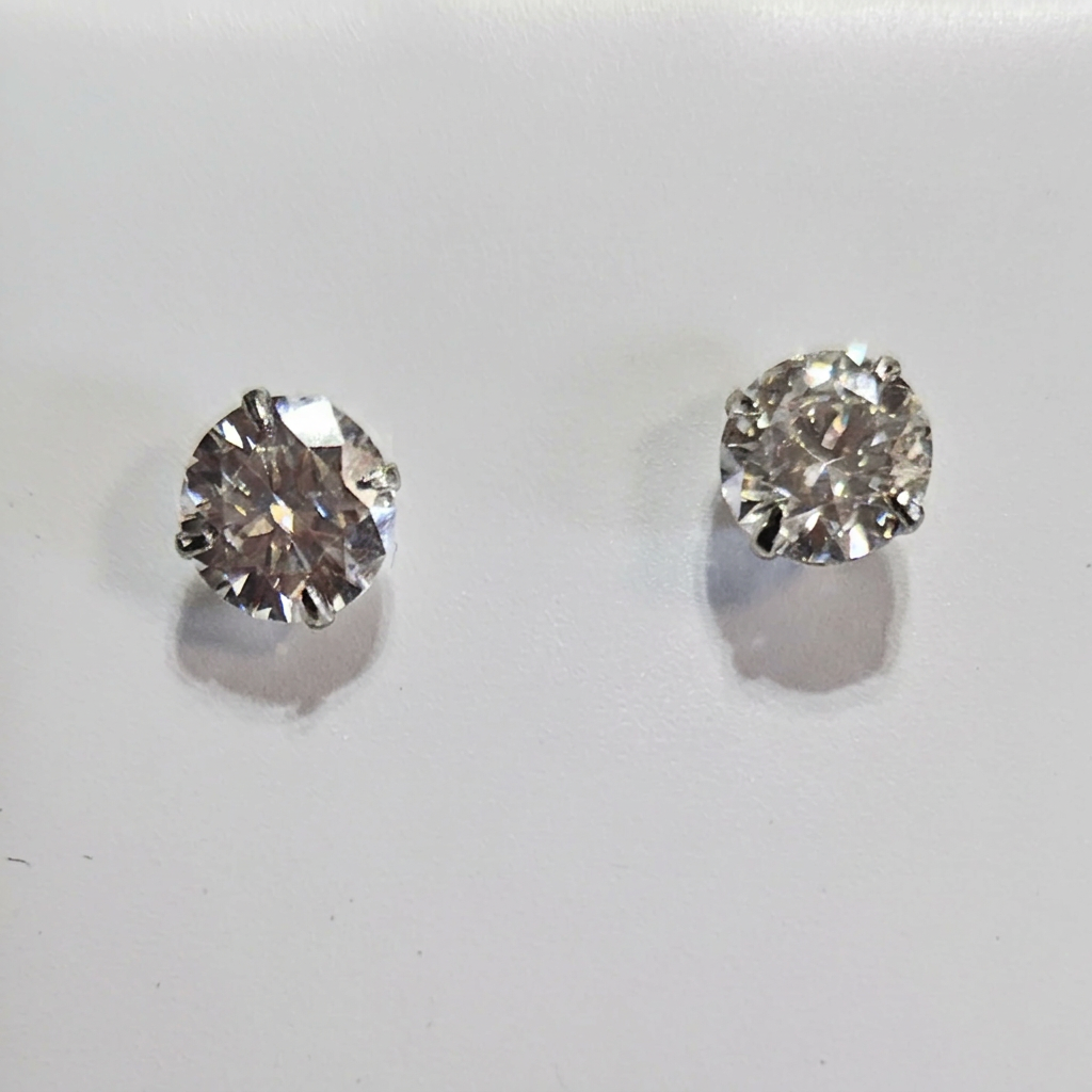 Close-up of round clear-stone studs with silver-tone prong settings